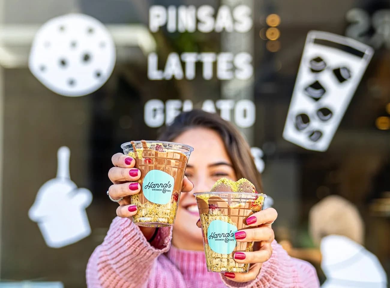A guest holding colorful drinks in Hanna’s branded cups